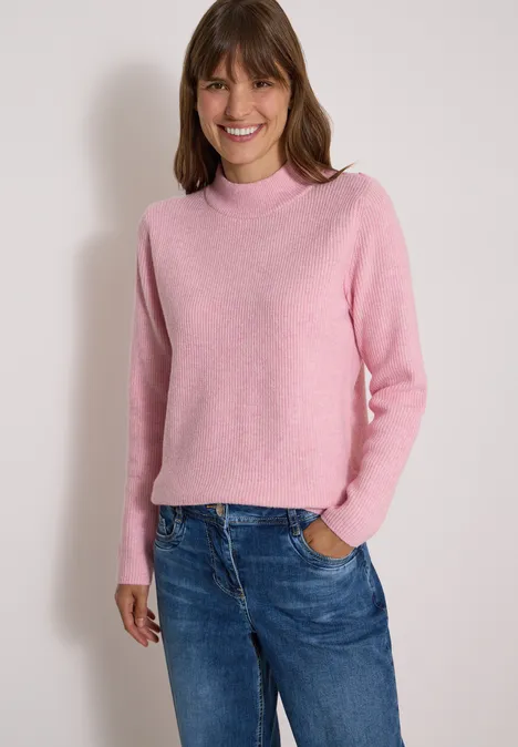 Pullover mit Struktur und Knopfdetail mellow rose melange Frau in rosa Pullover und blauen Jeans, leicht lächelnd vor hellem Hintergrund.
