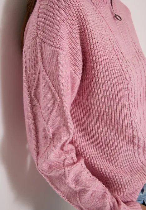 Rosa Strickpullover mit Zopfmuster und Rautendetails, eng am Oberkörper anliegend.