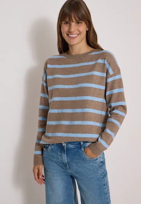 Pullover mit Boat Neck und Streifen urban taupe melange Frau trägt gestreiften Pullover in Braun und Hellblau sowie Jeans, lächelt und hat eine Hand in der Hosentasche.
