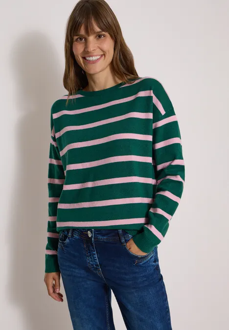 Pullover mit Boat Neck und Streifen dark fir green melange Frau mit grünem Streifenpullover und Jeans lächelt in die Kamera.