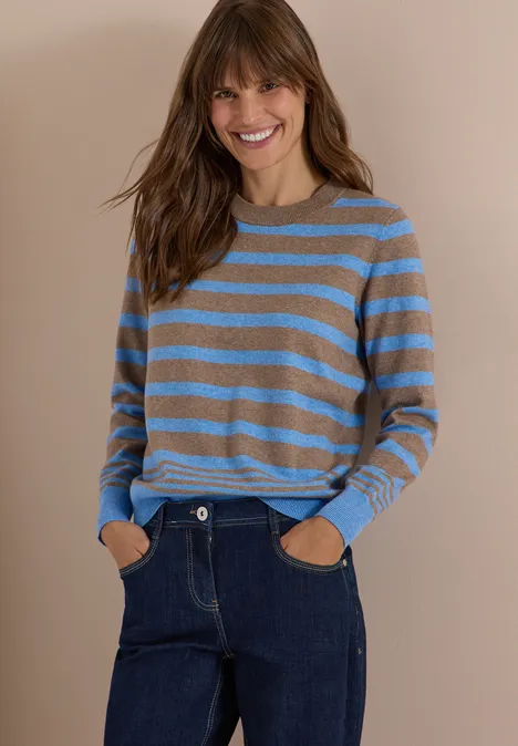 Pullover mit Rundhals und Streifen urban taupe melange Eine lächelnde Frau trägt einen blau-beige gestreiften Pullover und dunkle Jeans vor beigem Hintergrund.
