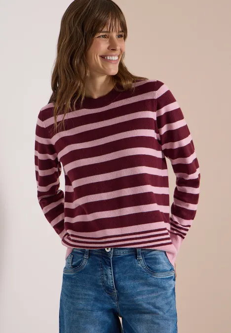 Pullover mit Rundhals und Streifen red wine melange Lächelnde Frau in rosa und burgunderfarben gestreiftem Pullover und Jeans vor neutralem Hintergrund.