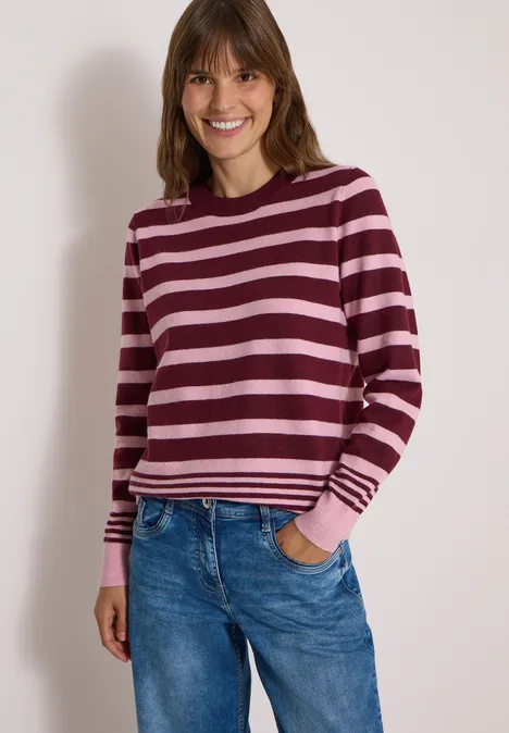 Pullover mit Rundhals und Streifen red wine melange Eine Frau in pink-bordeaux gestreiftem Pullover und Jeans lächelt vor hellem Hintergrund.