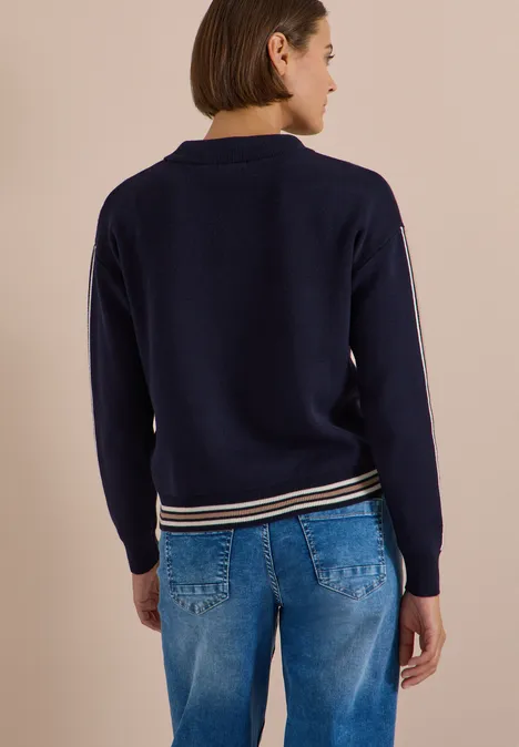Pullover mit Turtle Neck und College-Details urban dark blue melange Rückenansicht einer Frau in marineblauem Pullover mit gestreiftem Saum und blauen Jeans.