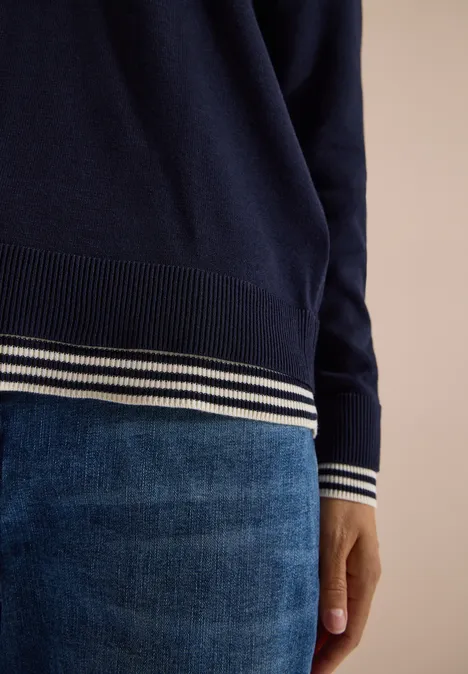 Pullover mit Rundhals und Layering-Detail urban dark blue Dunkelblauer Pullover mit weißen Streifen an Ärmeln und Saum, kombiniert mit jeansfarbener Hose.