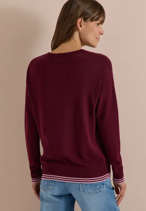 Pullover mit Rundhals und Layering-Detail red wine Frau von hinten in bordeauxrotem Pullover mit gestreiftem Bund und Jeans.