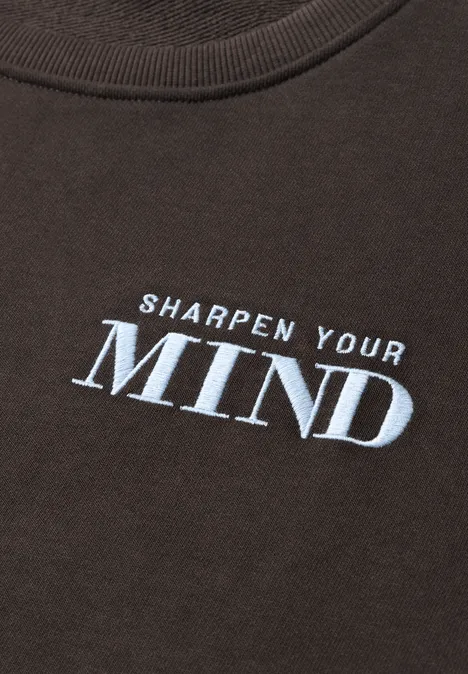 Dunkles T-Shirt mit weißem Aufdruck ‚SHARPEN YOUR MIND‘.