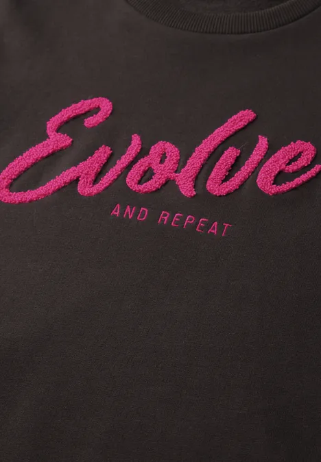 Zwart shirt met roze tekst "Evolve and Repeat"