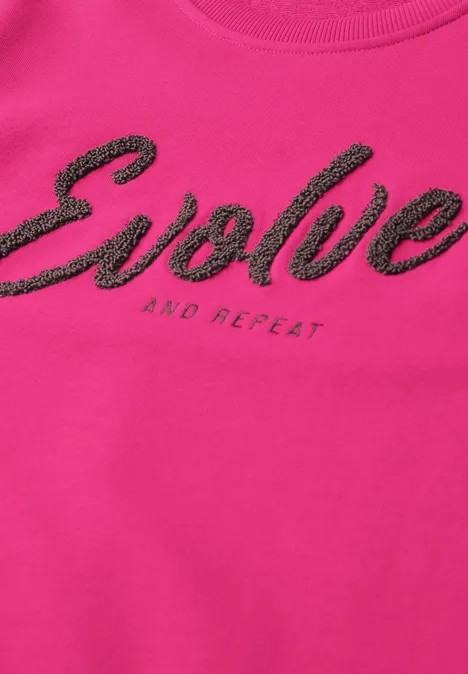 Sweatshirt met ronde hals en tekst pink flash Roze T-shirt met zwarte tekst 'Evolve' en klein 'and repeat' eronder.