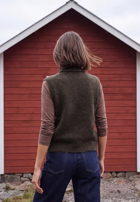 Vest zonder mouwen met kraag en argylepatroon truffle brown Persoon van achteren in groen vest en spijkerbroek voor een rood huis
