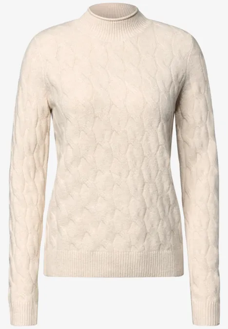 Beige coltrui met kabelpatroon, gebreid in zachte stof.