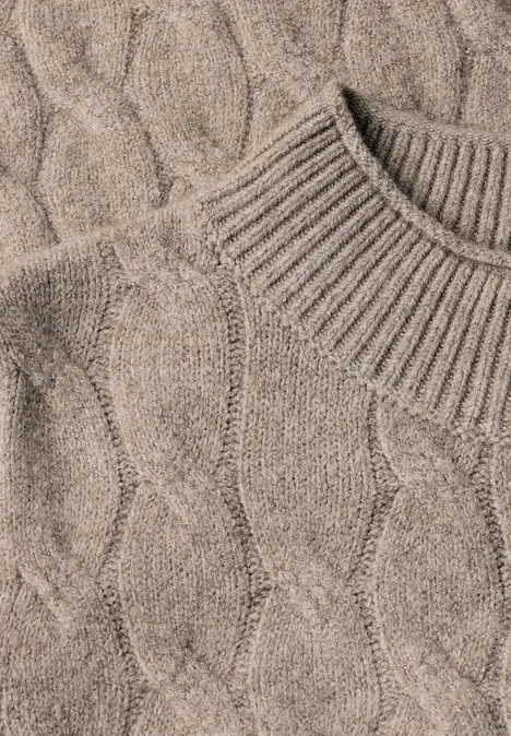 Pull beige épais en maille torsadée avec col montant.