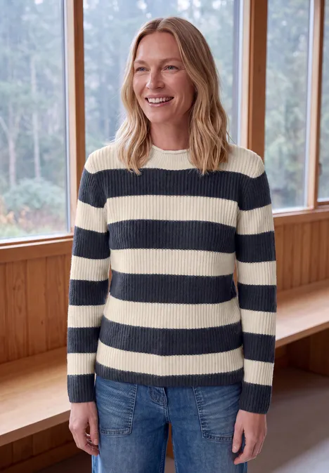 Pullover mit Turtle Neck und Streifen urban dark blue Lächelnde Frau in gestreiftem Pullover und Jeans, in hellem Raum vor großen Fenstern.
