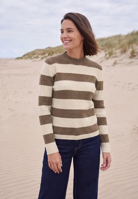 Pullover mit Turtle Neck und Streifen creamy mocha melange Eine lächelnde Frau trägt einen gestreiften Pullover und Jeans am Strand.