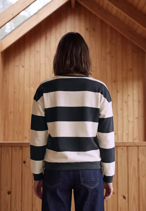 Person von hinten, gestreiftes Shirt, hölzerner Raum, natürliche Atmosphäre.