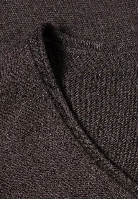 Gros plan d'un t-shirt noir à col en V en tissu fin et texturé.
