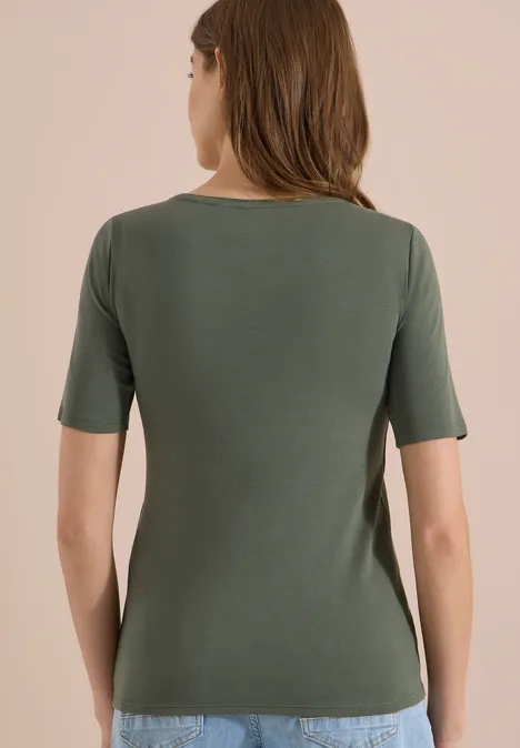 Rückansicht einer Frau in schmal geschnittenem, kurzärmeligem, olivgrünem T-Shirt.