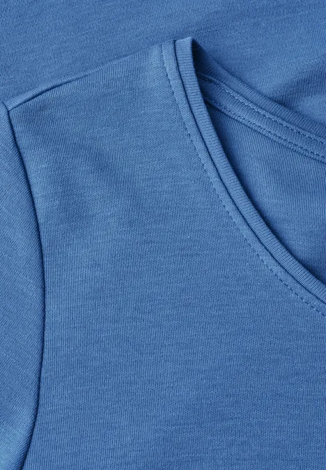 Detailaufnahme eines blauen T-Shirts mit Rundhalsausschnitt und glattem Baumwollstoff.