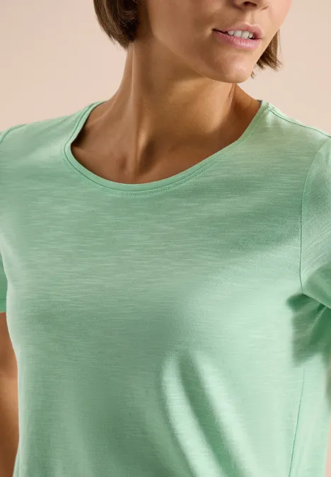 Close-up van een vrouw in lichtgroen T-shirt met ronde hals