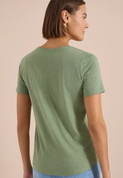 Frau von hinten in schlichtem grünen T-Shirt mit kurzen Ärmeln und Rundhalsausschnitt.