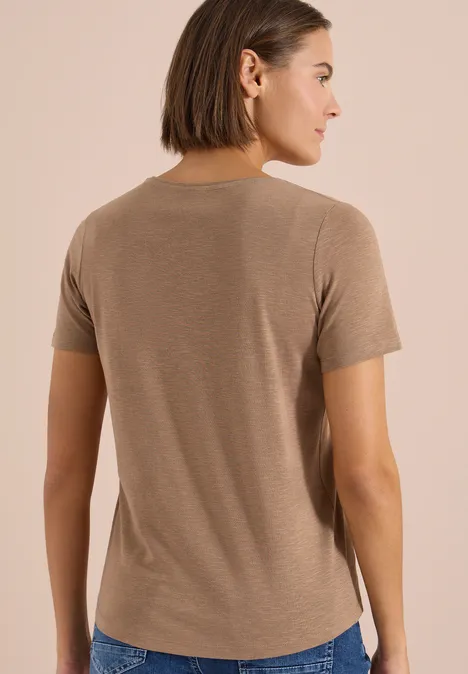 Basic Shirt met ronde hals creamy mocha Persoon van achteren in lichtbruin T-shirt tegen neutrale achtergrond.