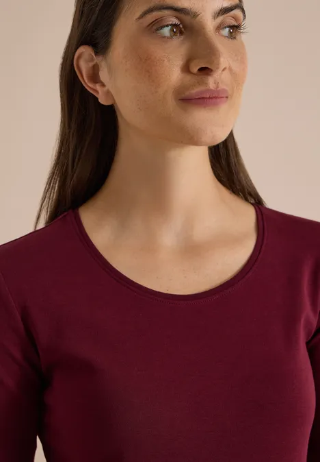Basic Langarm Shirt mit Rundhals red wine Nahaufnahme einer Frau mit langen, dunklen Haaren in einem burgunderfarbenen Oberteil.