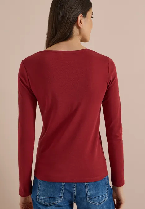 Basic Langarm Shirt mit Rundhals russet red Frau von hinten in rotem Langarmshirt und blauen Jeans.