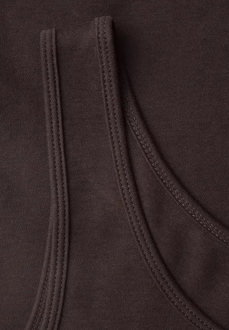 Basic top van puur katoen truffle brown Close-up van twee donkerbruine katoenen shirts, over elkaar gelegd met zichtbare naden