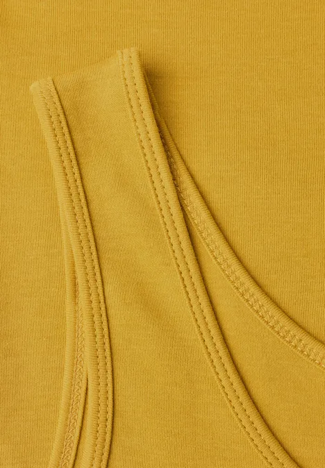 Detailaufnahme eines senfgelben Top-Stoffes mit Schulterträger