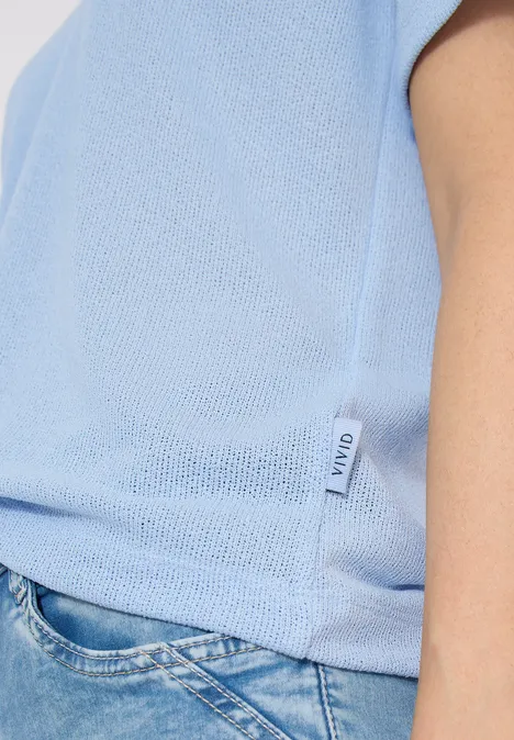 Effen polo met korte mouwen fresh water blue Zijaanzicht van persoon in lichtblauw shirt en blauwe jeans, klein merkje zichtbaar.