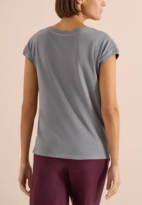 Shirt met korte mouwen en rimpels graphite light grey Vrouw van achteren in een grijs T-shirt met korte mouwen en een paarse broek, casual stijl.