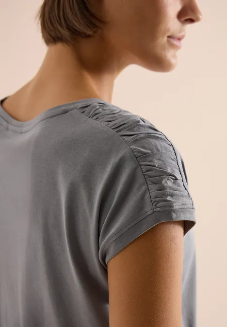 Shirt met korte mouwen en rimpels graphite light grey Achteraanzicht van een persoon in een grijs T-shirt met geraffineerde plooien op de schouder.