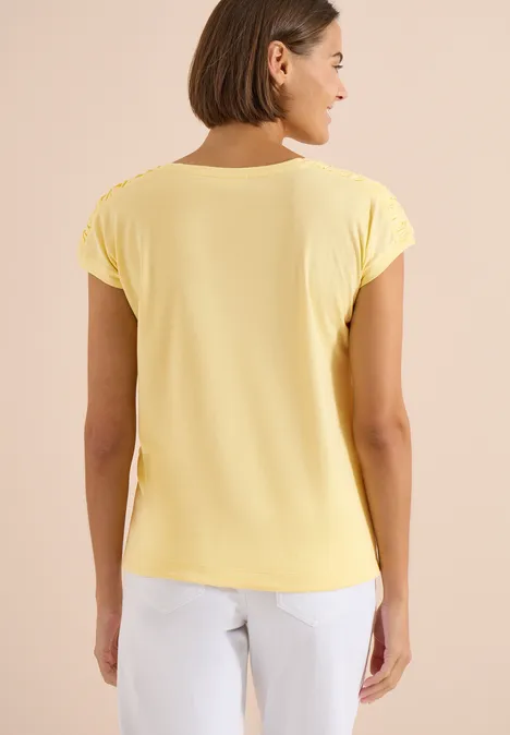 Shirt met korte mouwen en rimpels buttermilk yellow Rugaanzicht van een persoon in geel t-shirt en witte broek tegen neutrale achtergrond.