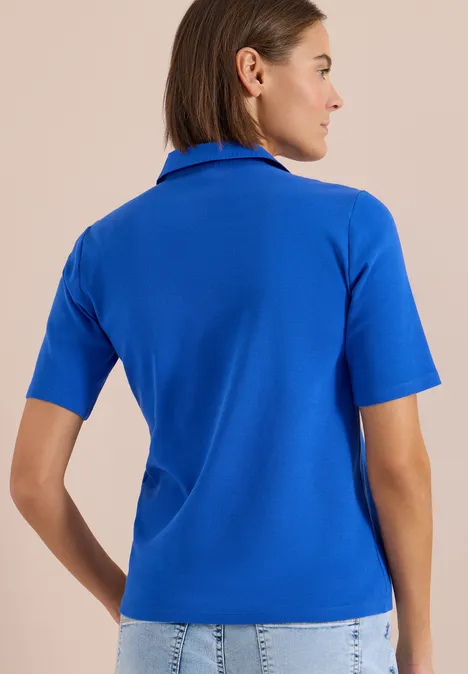 Basic Poloshirt mit Kurzarm surf blue Frau von hinten in royalblauem kurzärmligen Polo-Shirt