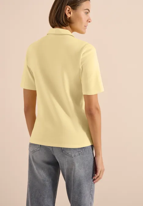 Basis polo met korte mouwen buttermilk yellow Achteraanzicht van een vrouw in geel poloshirt en spijkerbroek