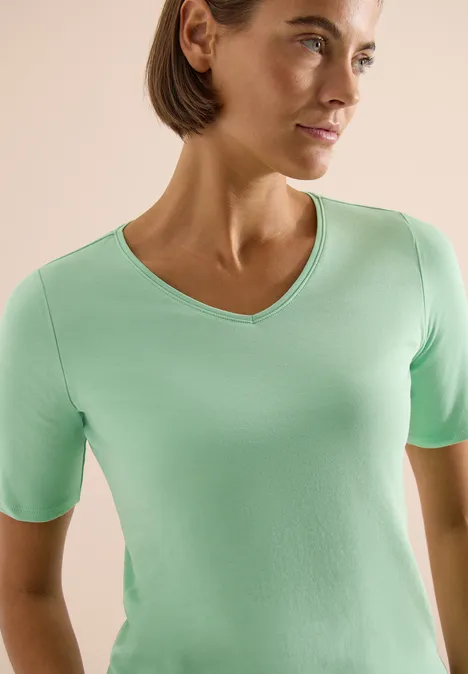 Basic katoenen shirt juicy lime Iemand draagt een lichtgroen T-shirt met korte mouwen en V-hals tegen een lichte achtergrond.