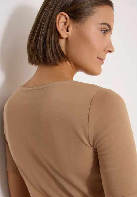 T-shirt basique en coton creamy mocha Personne vue de dos, cheveux bruns au carré, portant un haut beige.