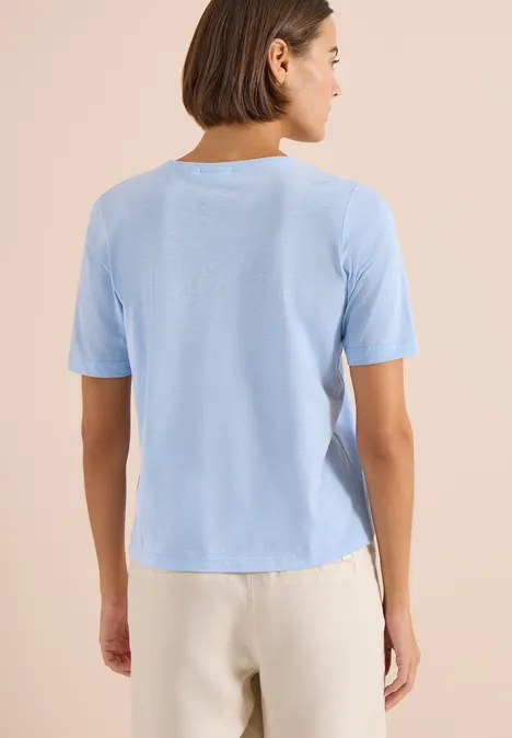 Basic Shirt met V-hals light sky blue Persoon gezien van achteren, draagt een lichtblauw T-shirt en een lichte broek.