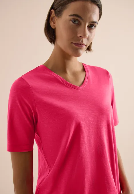 Basic Shirt met V-hals geranium red Vrouw in roze V-hals T-shirt tegen een neutrale achtergrond