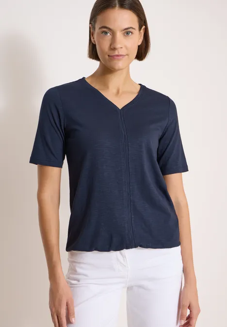 Kurzarm T-Shirt im Tunika-Look universal blue Frau trägt marineblaues V-Neck-Shirt und weiße Hose, Vorderansicht bis Hüfte.