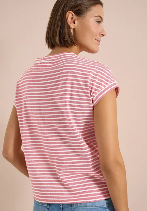Eine Person mit kurzärmeligem, rot-weiß gestreiftem T-Shirt sitzt mit dem Rücken zur Kamera.