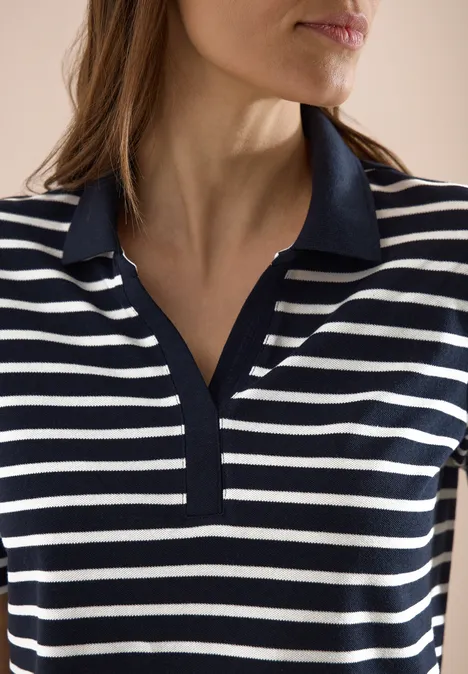Frau im Close-up mit blau-weiß gestreiftem Poloshirt und V-Ausschnitt