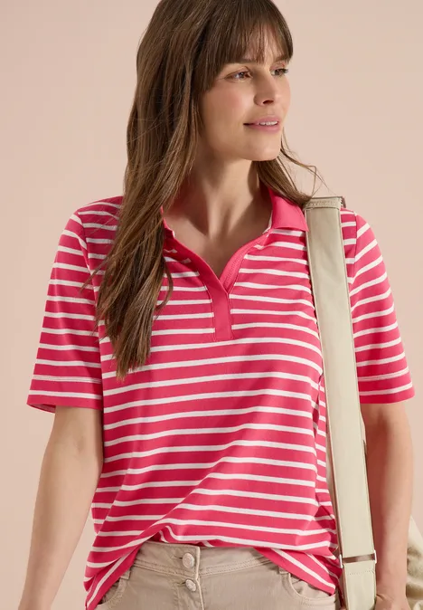 Frau in rosa-weiß gestreiftem Poloshirt und Umhängetasche