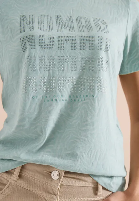 Shirt met korte mouwen in burnout-look crystal mint Lichtgroen T-shirt met zebraprint en "NOMAD NUMBER" opdruk, gecombineerd met beige broek