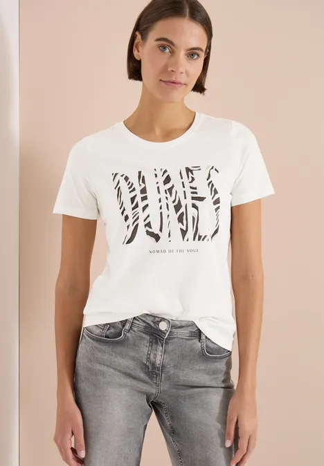 T-Shirt mit Rundhals und Frontprint vanilla white Frau trägt weißes T-Shirt mit Zebra-Print-Schriftzug und grauen Jeans.