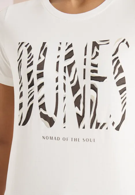 T-Shirt mit Rundhals und Frontprint vanilla white Weißes T-Shirt mit großem, gestreiftem DNES-Aufdruck und kleinem Schriftzug „NOMAD OF THE SOUL“.