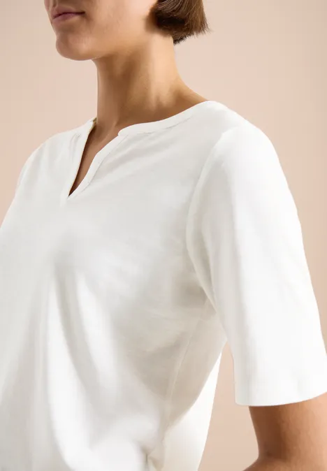 Shirt met gespleten hals in effen kleur vanilla white Bovenlichaam van een persoon in een eenvoudig wit T-shirt met V-hals en halflange mouwen.