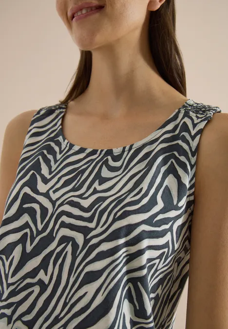 Top met ronde hals en plooidetails palm breeze green Vrouw draagt mouwloos topje met zebrapatroon voor een effen achtergrond.