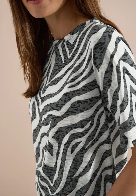Een vrouw draagt een T-shirt met zebraprint.