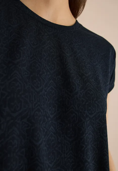 Shirt met burn-out look universal blue Close-up van een donkerblauw T-shirt met subtiel patroon en ronde hals.